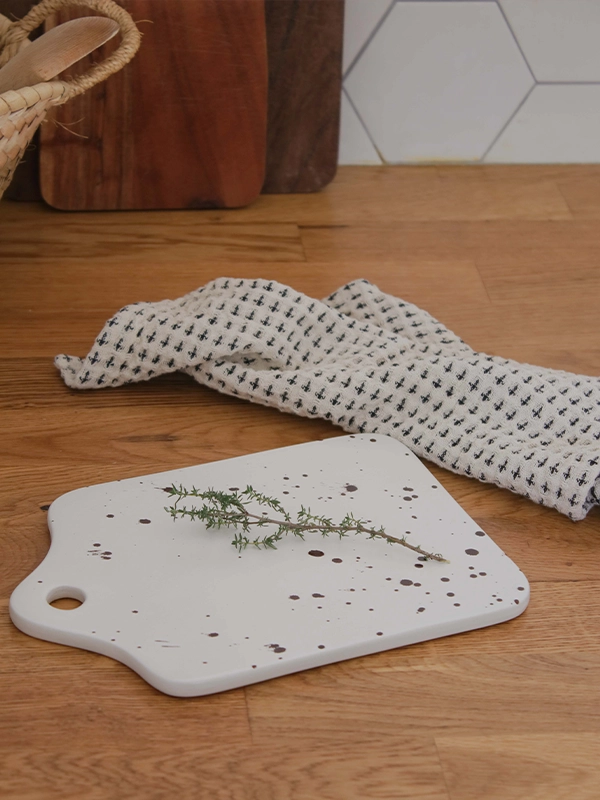 Planche céramique tachetée artisanale en grès blanc d'inspiration terrazzo. Décorez votre cuisine avec nos objets du quotidien comme cette planche en céramique ultra originale.