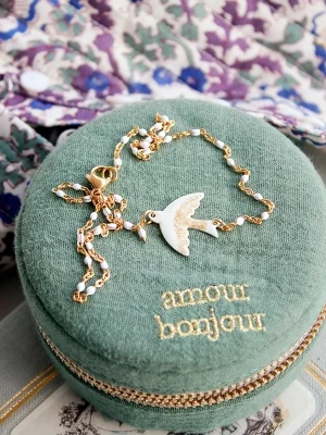 collier colombe dorée, symbolique de la paix. Jolie chaine fine dorées avec perles blanches, surmonte d'une breloque oiseau.