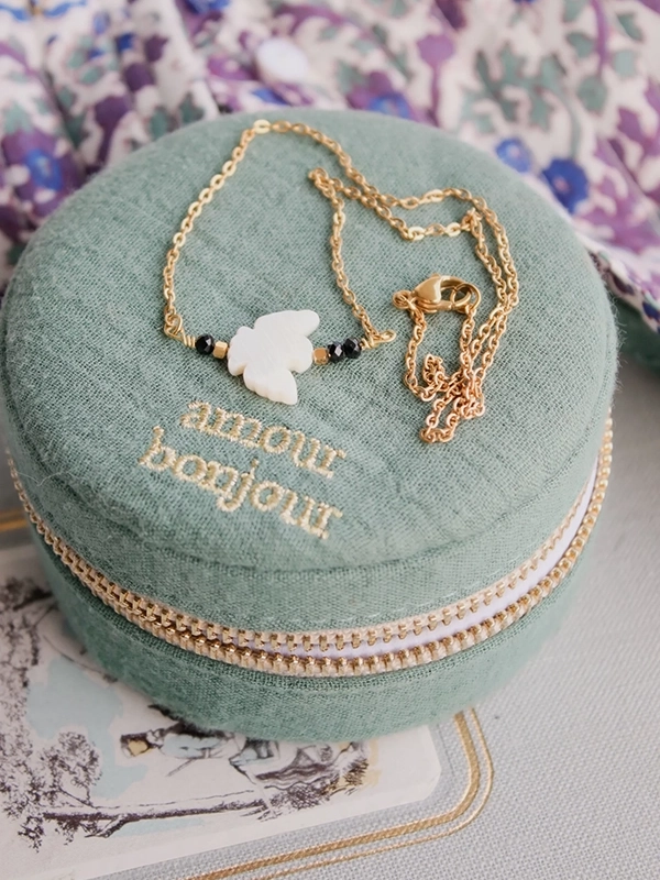 Collier oiseau blanc: symbole de paix, idéal pour les communions.